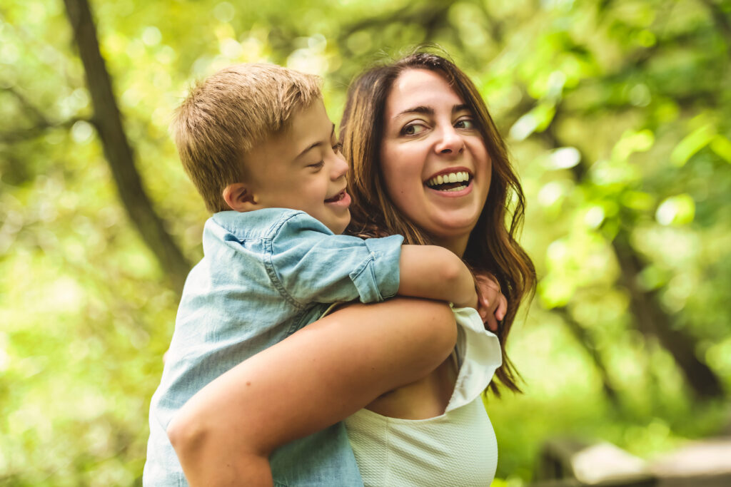 A Portrait of a little boy with down syndrome while playing in a park with his mother